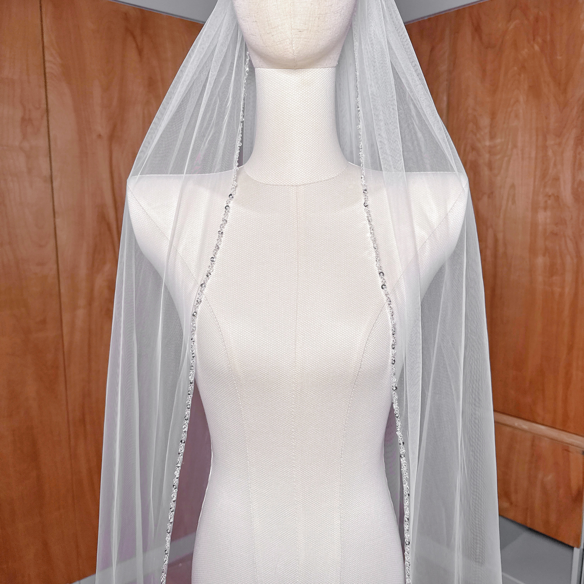 Cathedral length beaded edge wedding veil displayed on a bridal bust showcasing the intricate border detail.
