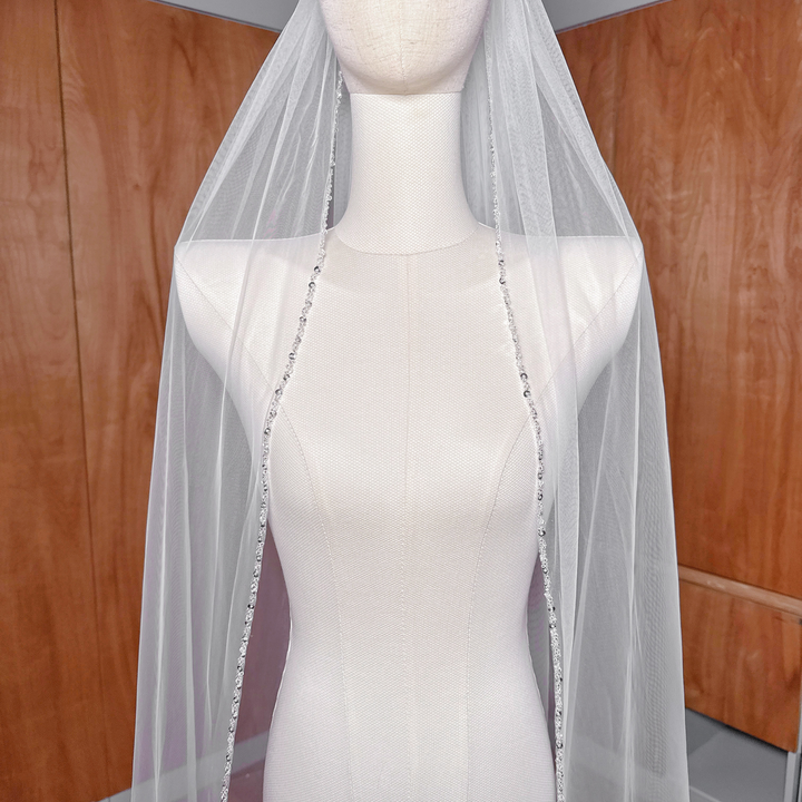 Cathedral length beaded edge wedding veil displayed on a bridal bust showcasing the intricate border detail.