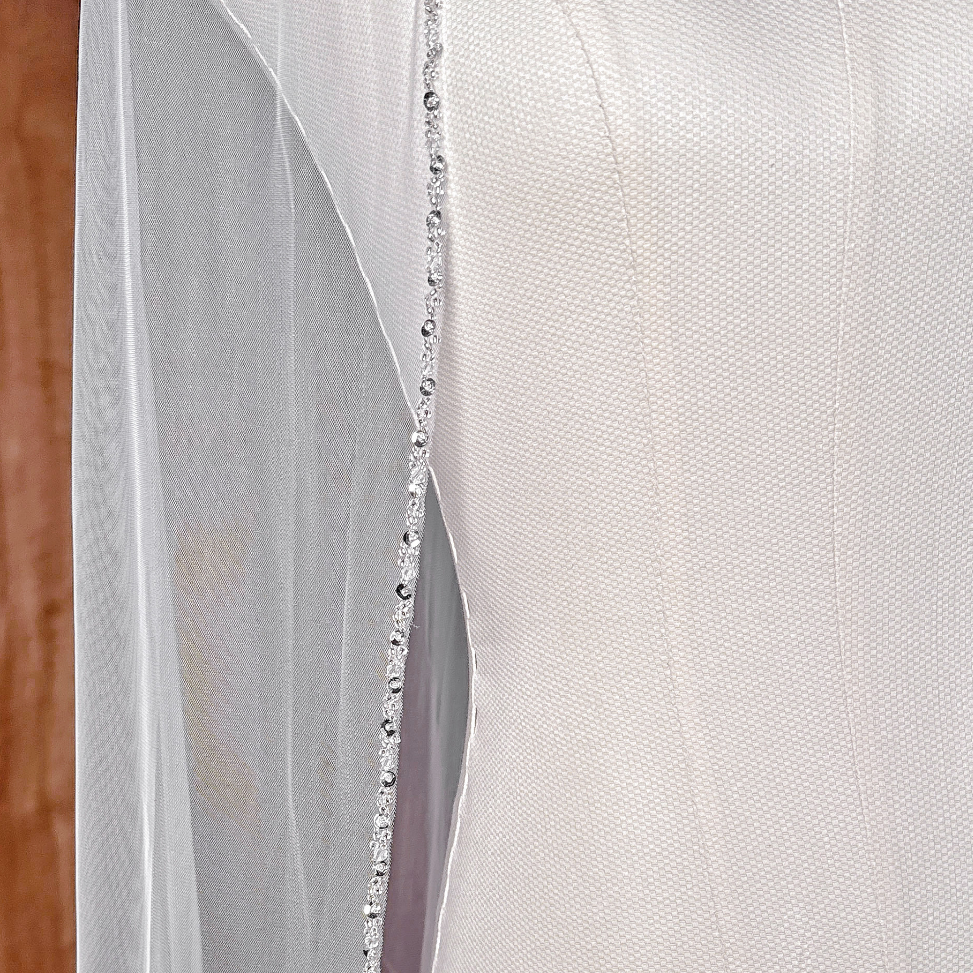 Close-up of a cathedral style wedding veil with premium beaded edge trim details.