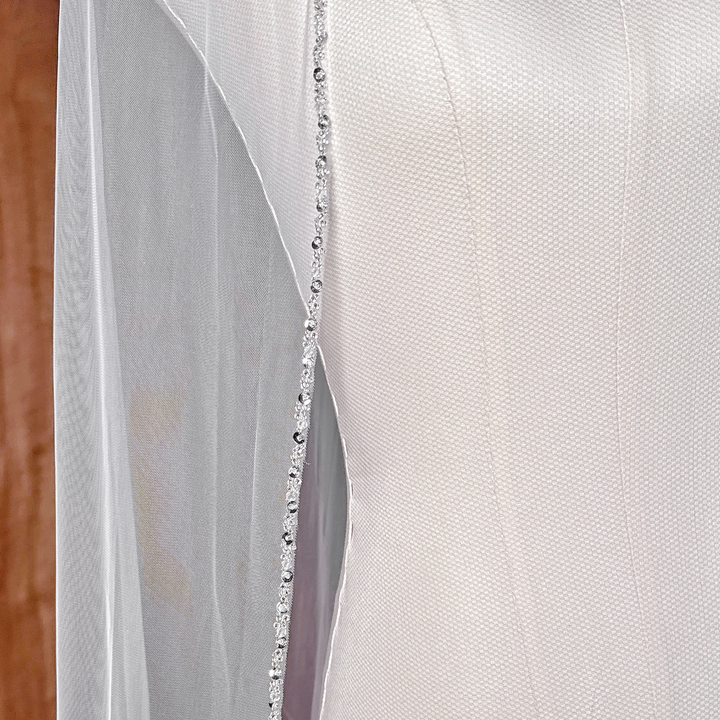 Close-up of a cathedral style wedding veil with premium beaded edge trim details.