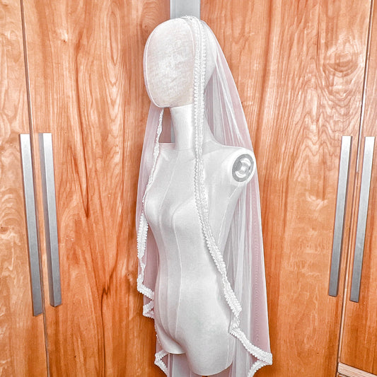 Side profile view of a beaded mantilla wedding veil.