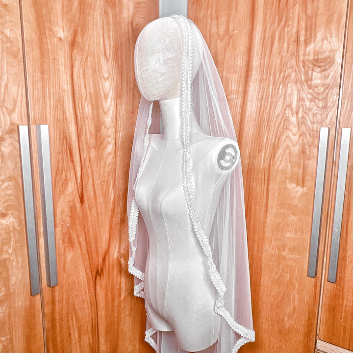Side profile view of a beaded mantilla wedding veil.