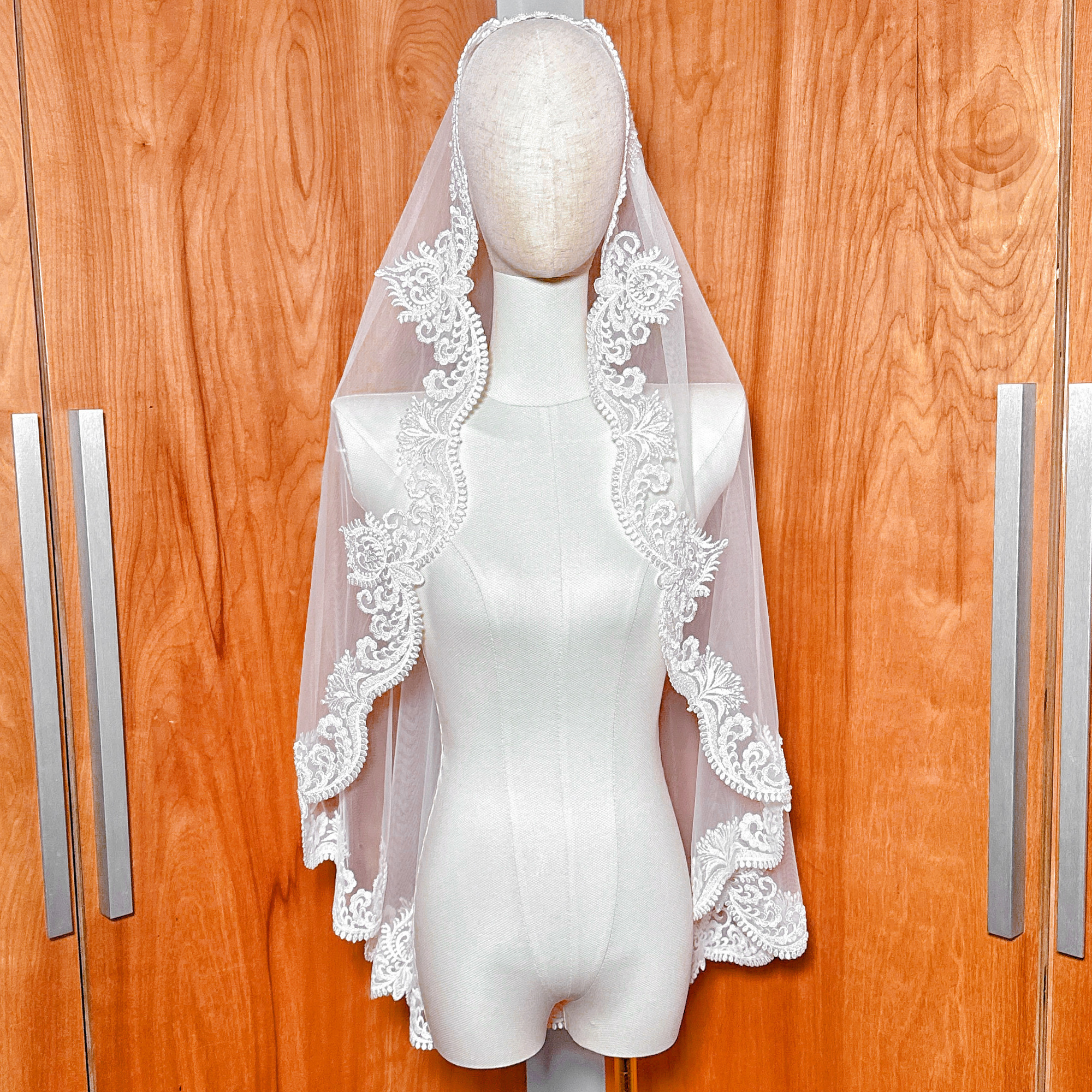 Beaded Scalloped Lace Mantilla Veil in fingertip length displayed on a mannequin to show the intricate embroidery and drape.