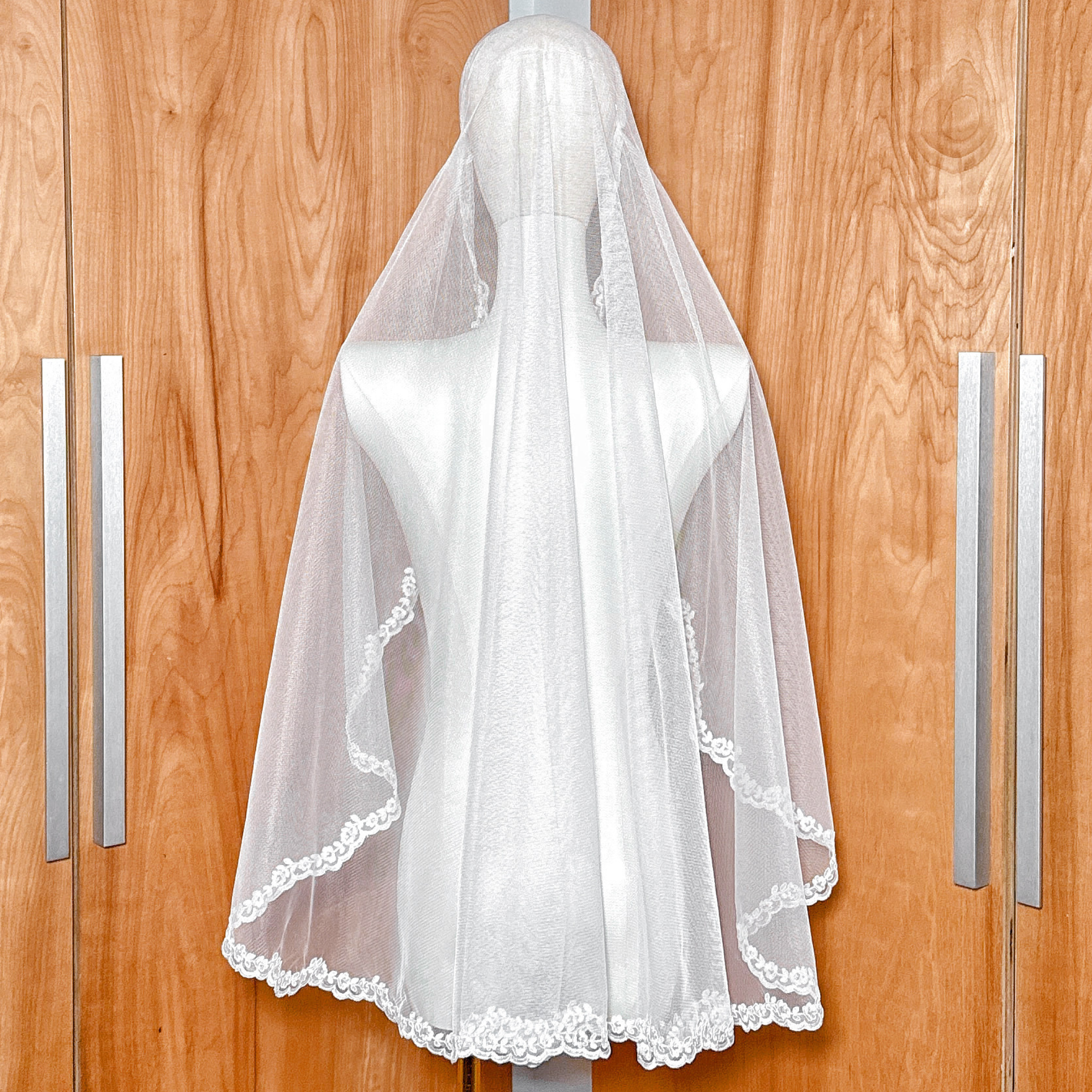 Back view showing the flow of soft tulle from an Alençon lace Juliet cap at fingertip length.