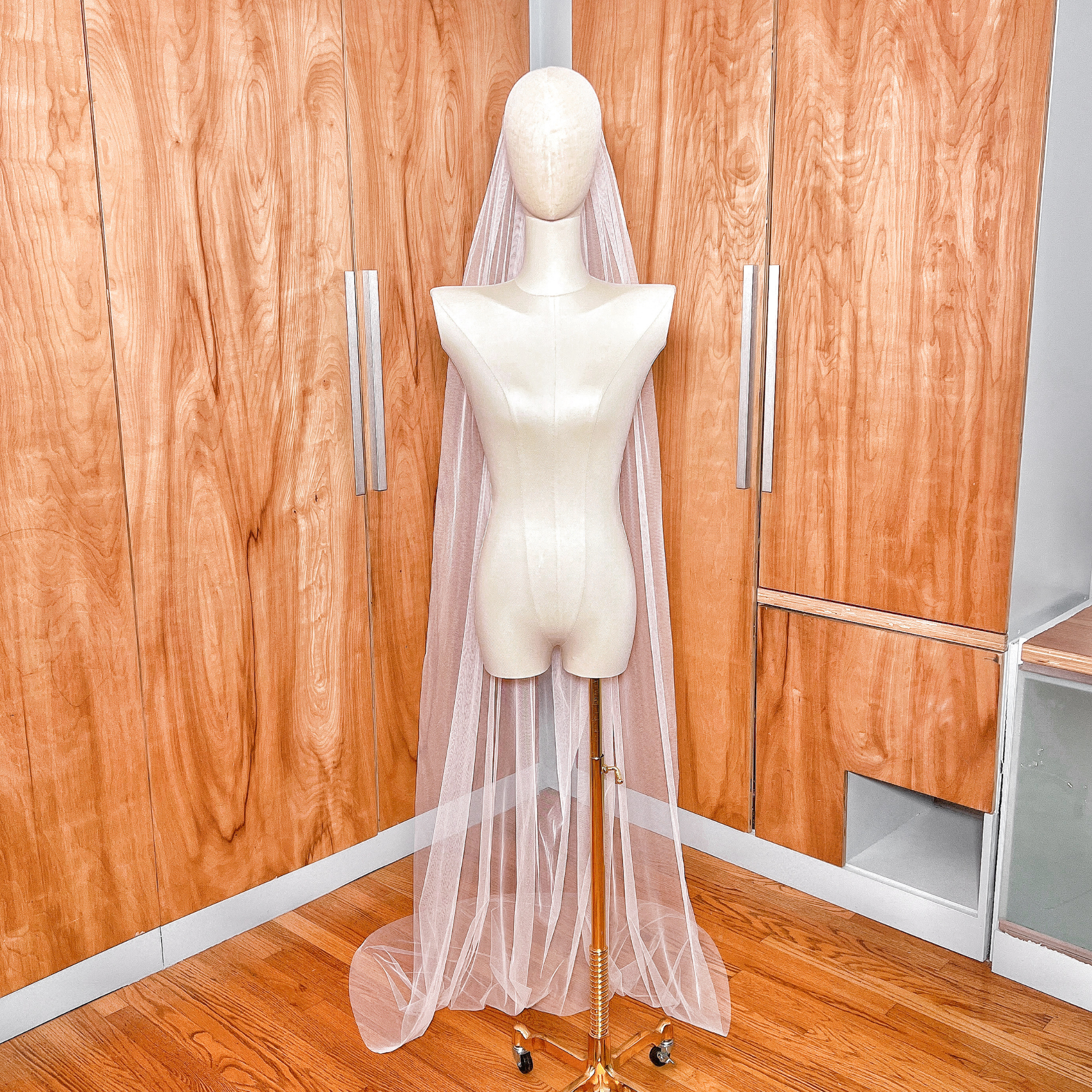 Floor length boho draped wedding veil with soft tulle folds displayed on a bridal bust.