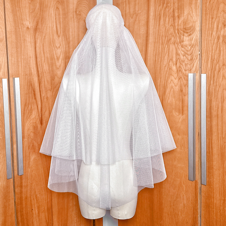 Boho juliet cap veil with a sheer blusher layer draped over a mannequin head.