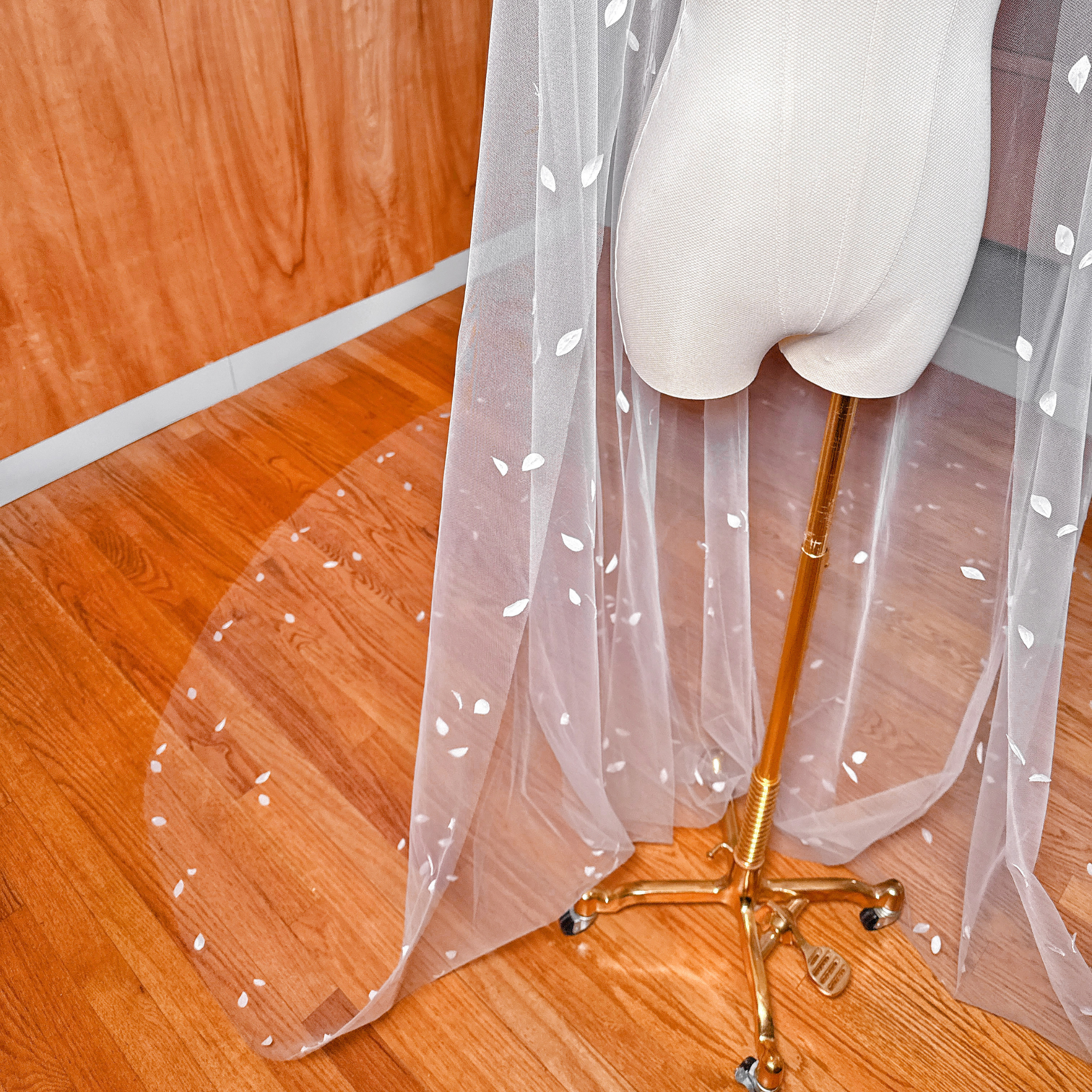 Intricate floral applique and silk petals along the hem of a cathedral length wedding veil.