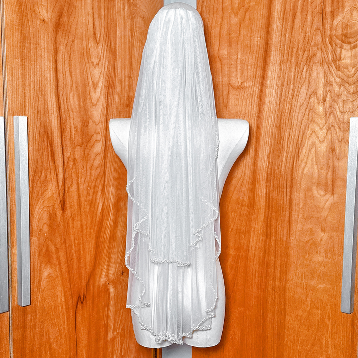 Back view of a two tier wedding veil with a beaded edge falling to hip length.