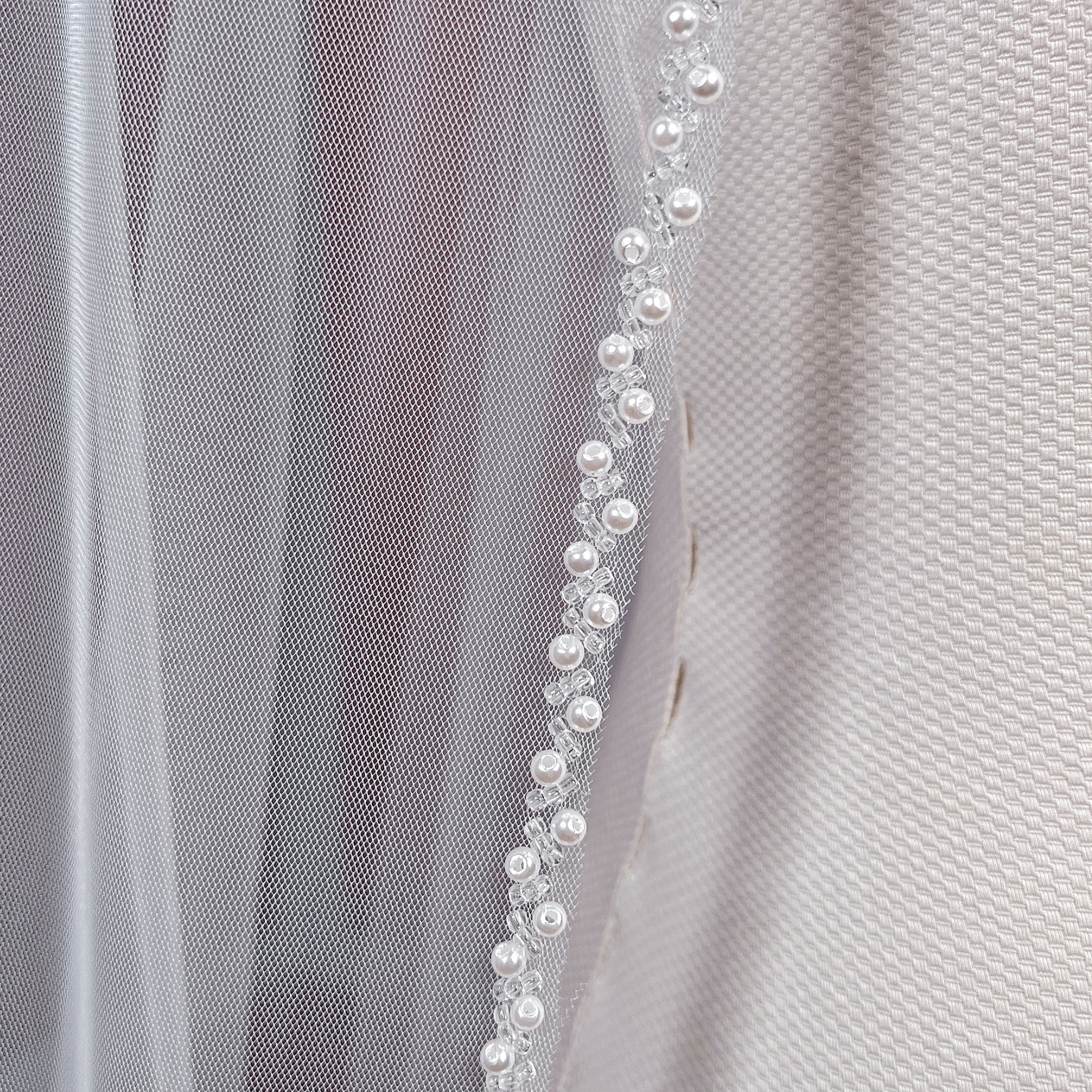 Elegant cathedral length beaded edge wedding veil flowing down beautifully.