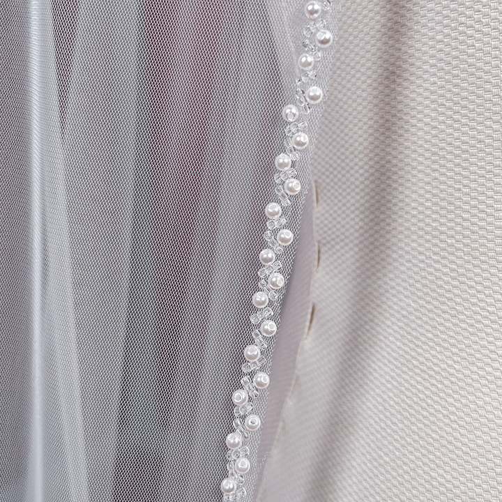 Elegant cathedral length beaded edge wedding veil flowing down beautifully.