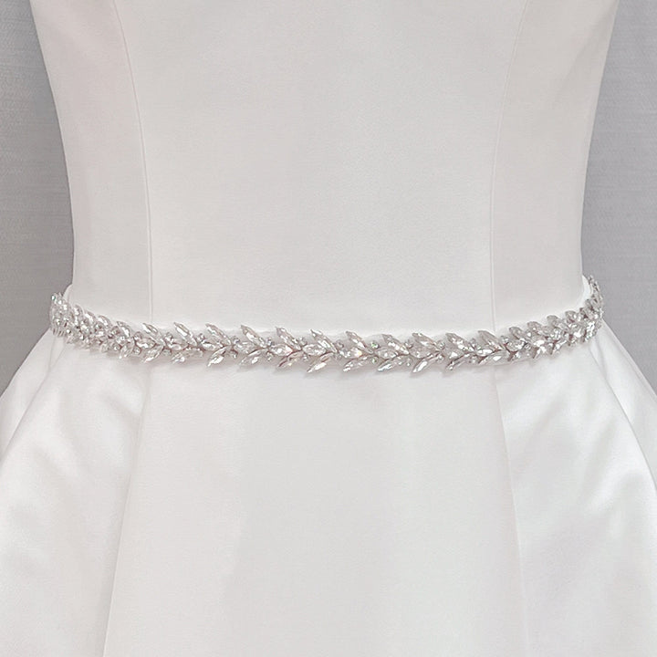 Elegant crystal rhinestone wedding dress sash and silver beaded bridal belt shown on a display mannequin.