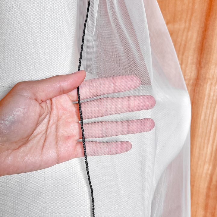 Close-up of a sheer black pencil edge wedding veil in fingertip length on a display mannequin.
