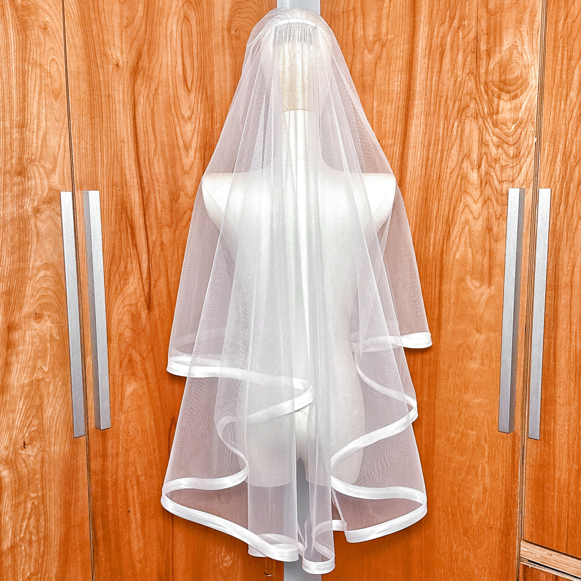 Back view of the one-inch satin ribbon edge on a fingertip length blusher veil.