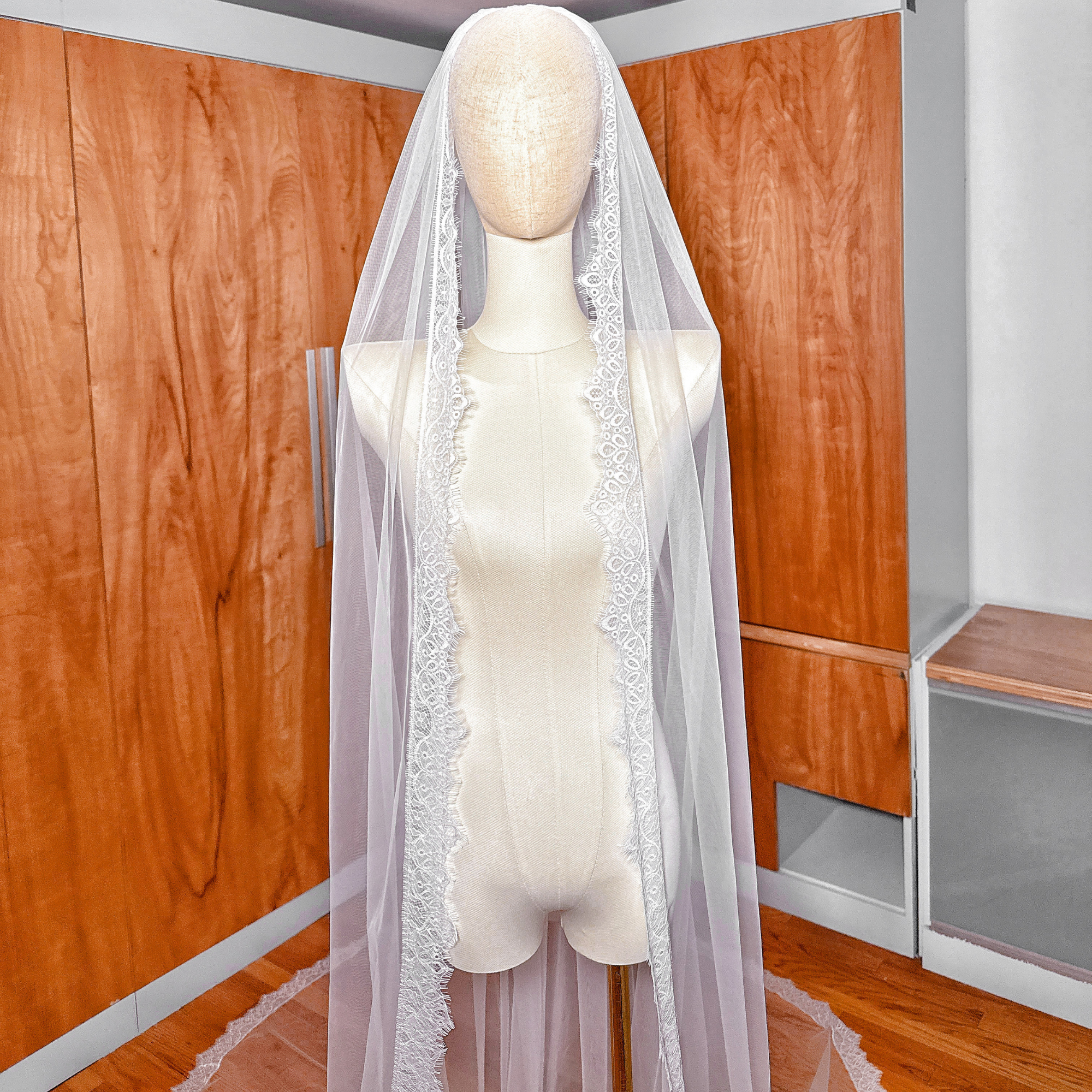 Single tier Chantilly lace veil cathedral length displayed on a bridal mannequin.