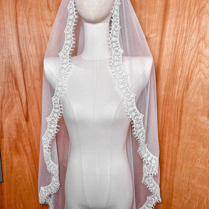 Detail shot of the scalloped eyelash lace edge on a waltz length mantilla wedding veil.