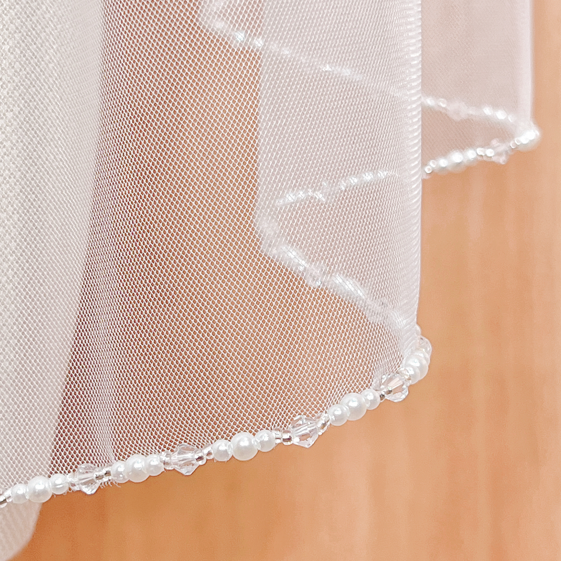 Pearl and crystal edge wedding veil in fingertip length.