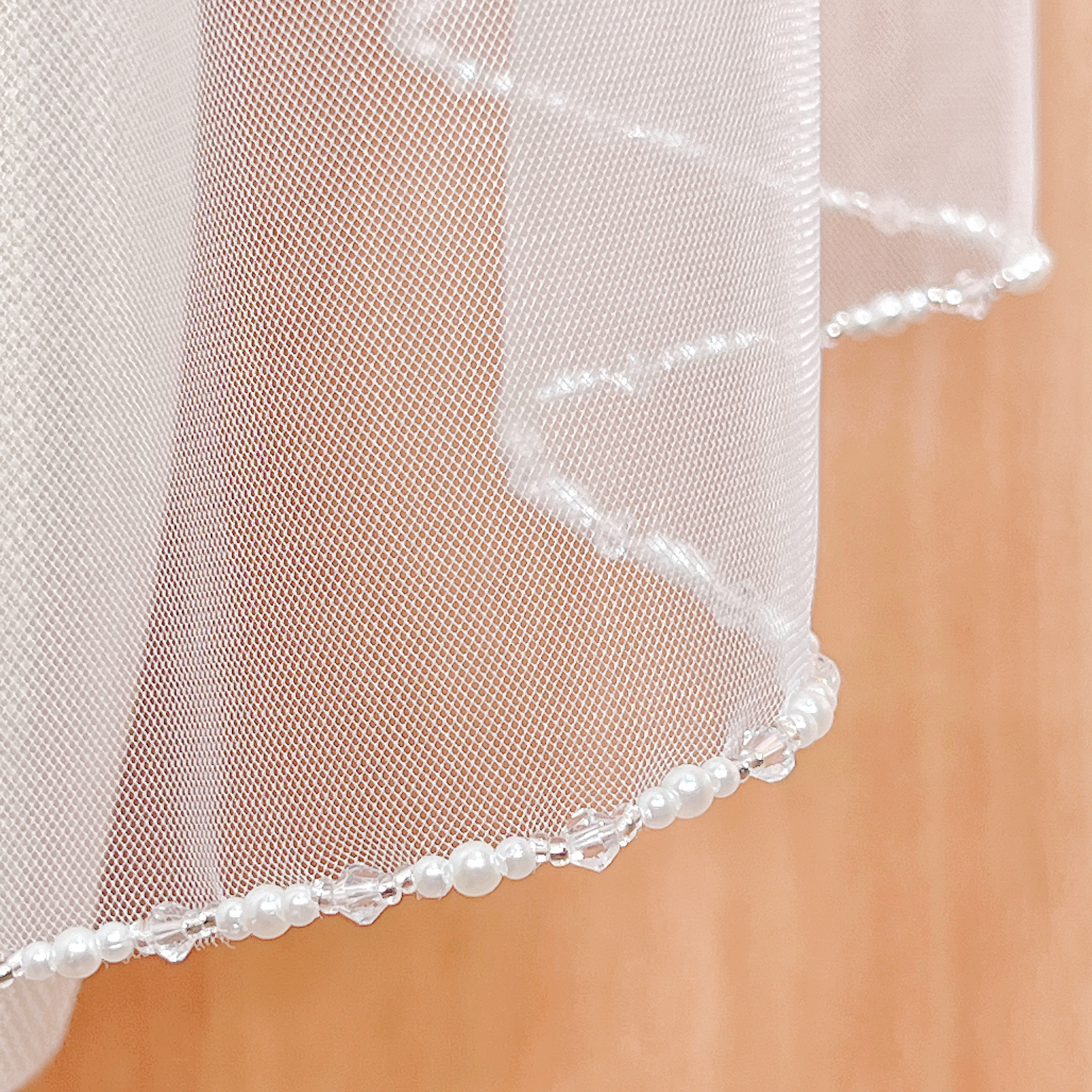 Pearl and crystal edge wedding veil in fingertip length.