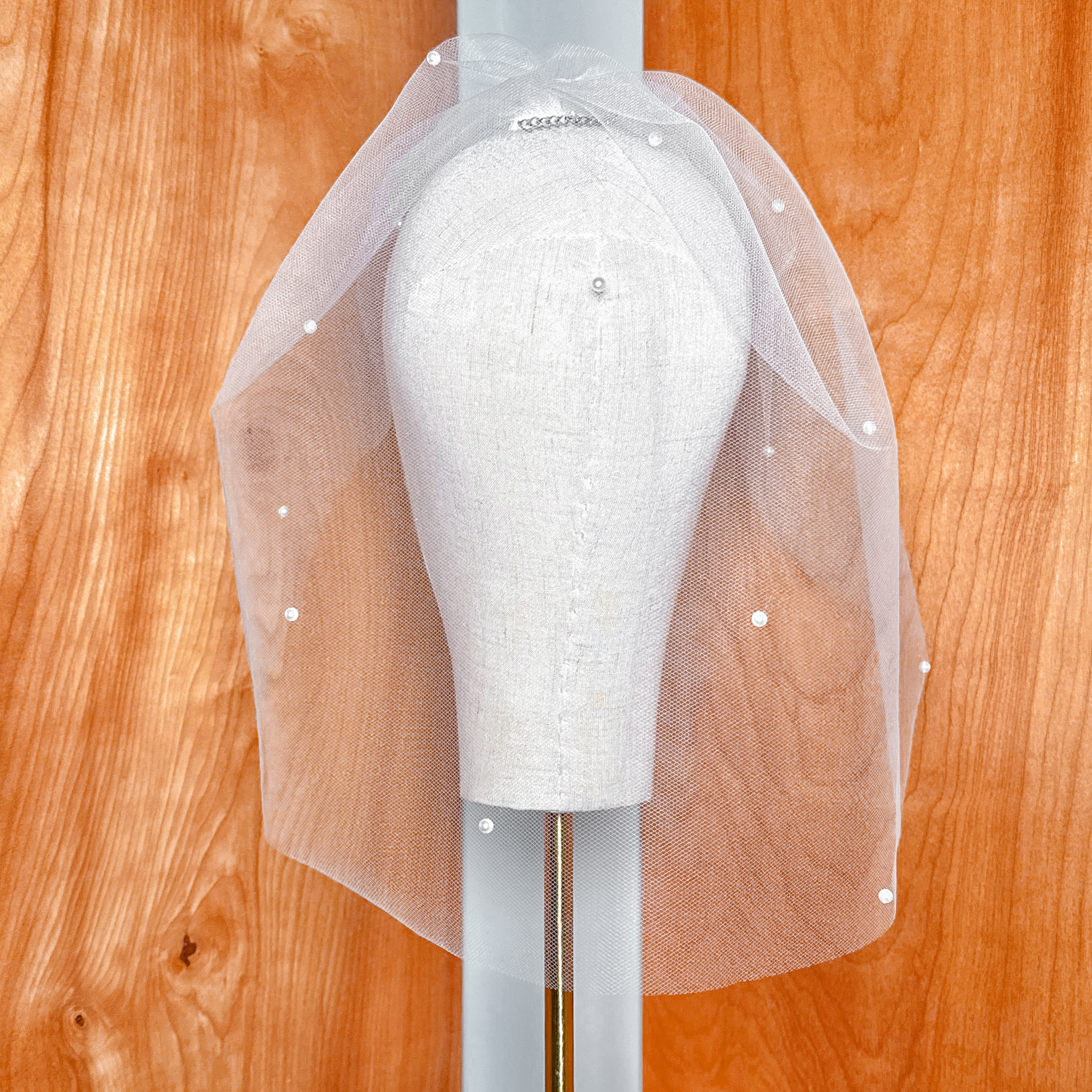 Detailed texture of a bridal pearl birdcage wedding veil netting and scattered pearls.