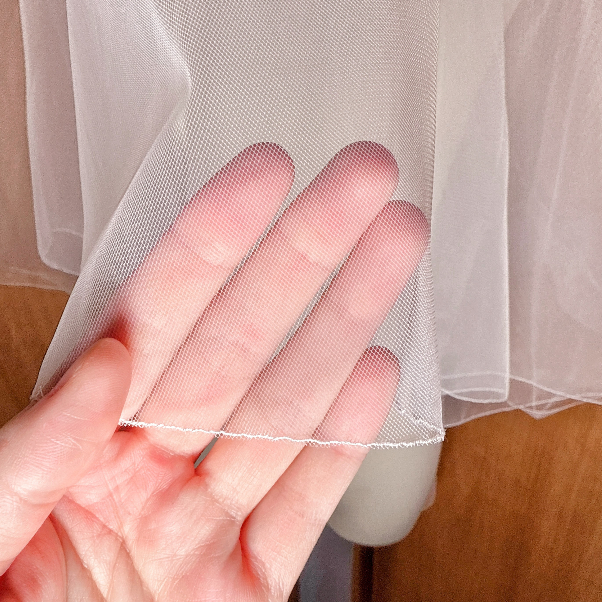 Close-up detail of the delicate finished trim on a Bridal Pencil Edge Two Tier Fingertip Length Veil.