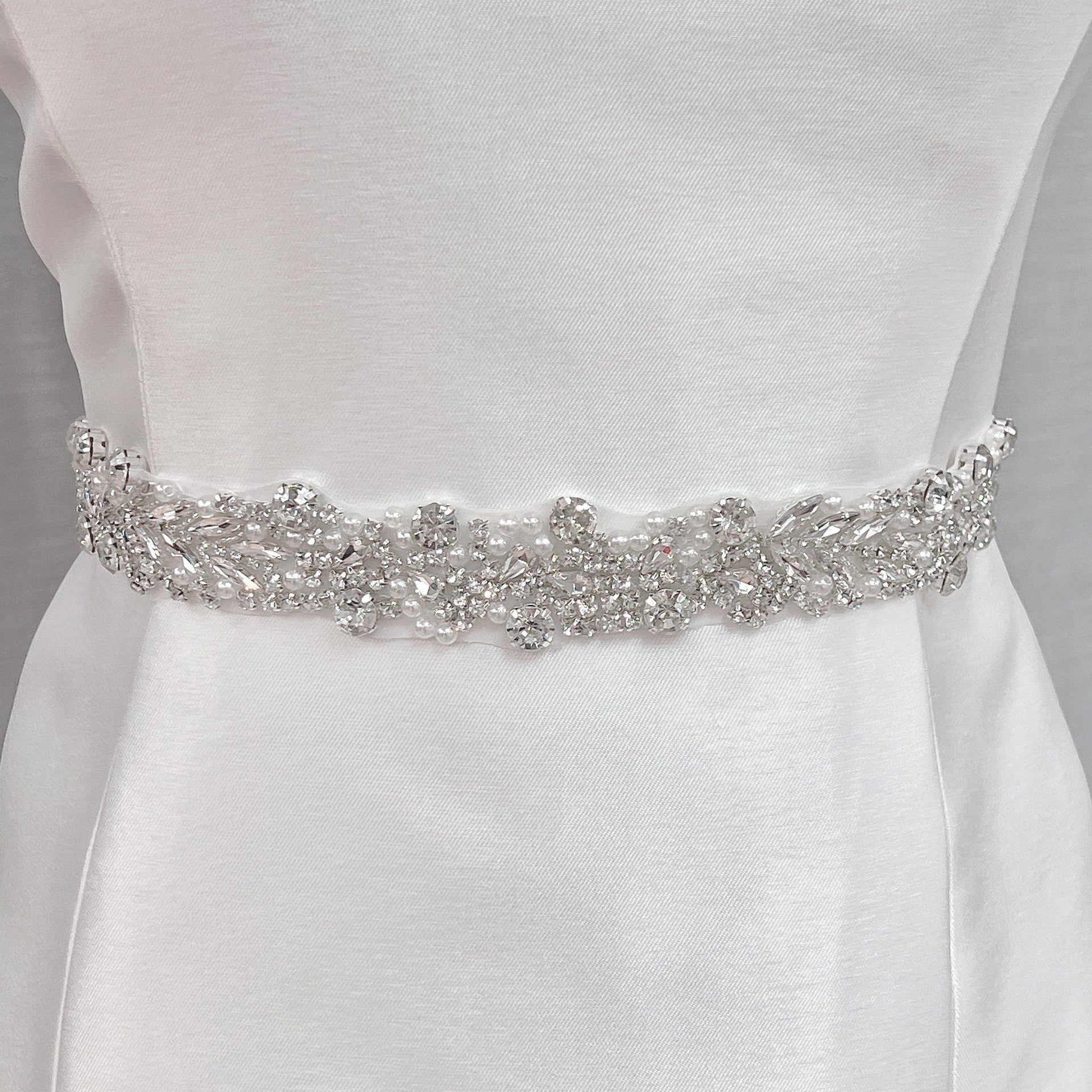 Elegant silver beaded bridal belt, 1.2 inches wide, showcasing intricate beadwork on a bridal mannequin.