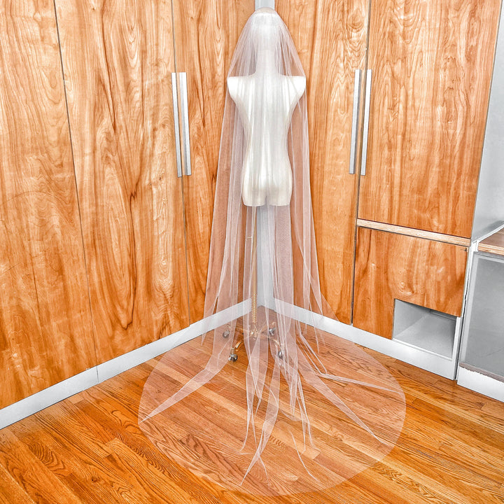 Rear view of a sheer single tier chapel length veil showing the airy flow and floor-length tulle drape.