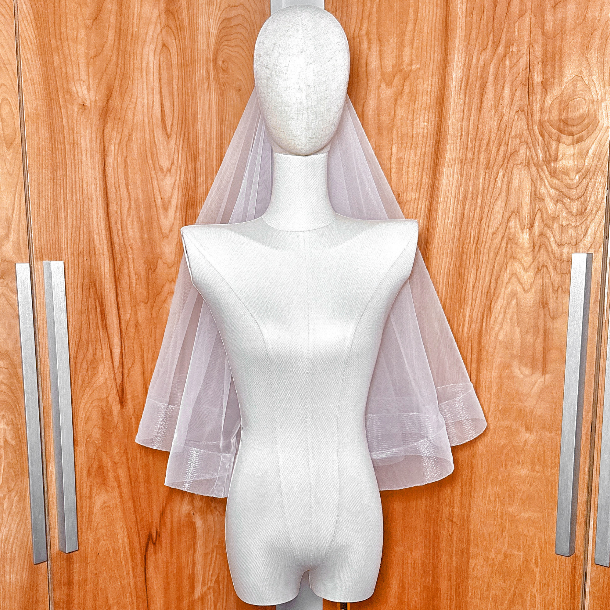 A classic elbow length two tier wedding veil with a 2 1/2" horsehair border and blusher attachment.