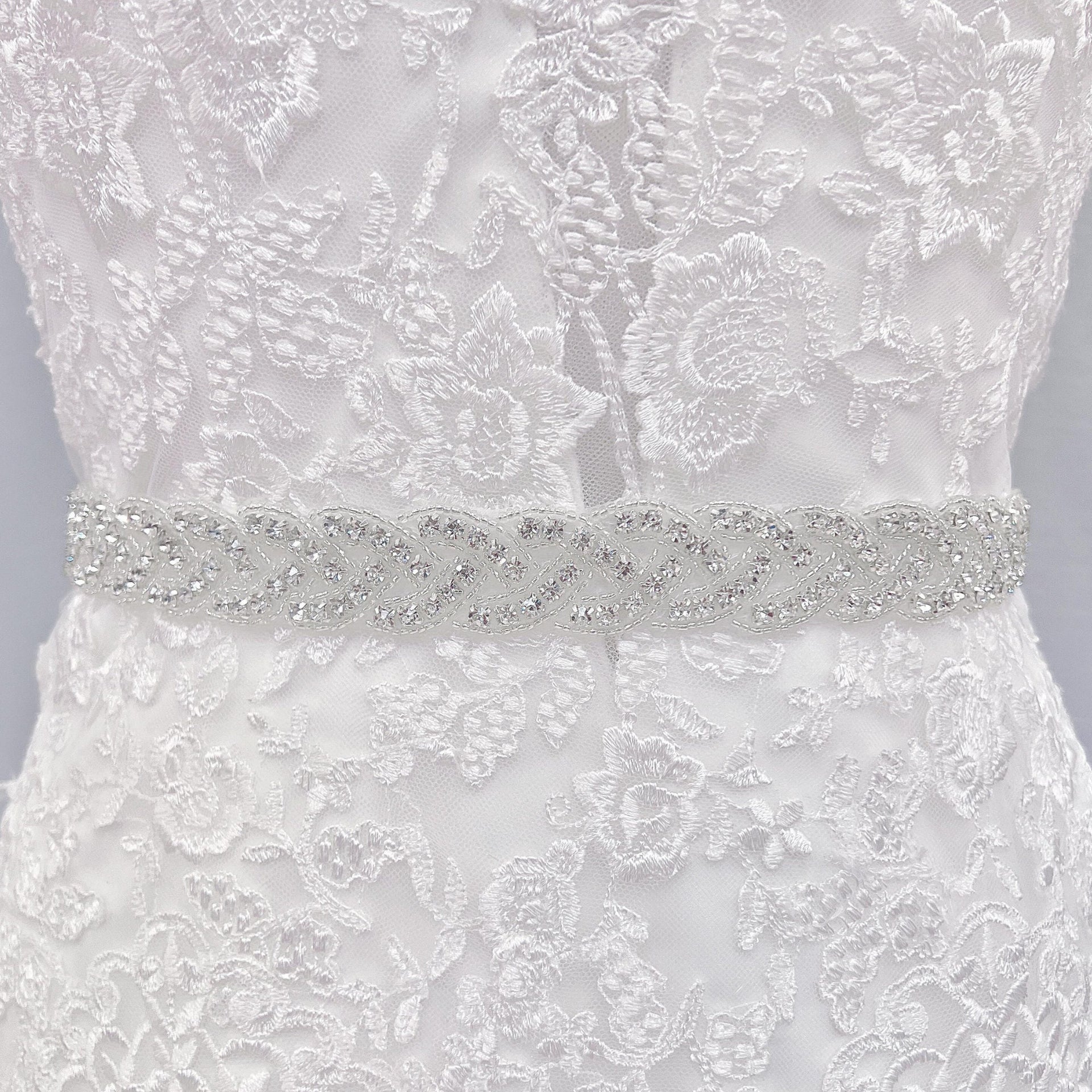 Close-up of a sparkling silver rhinestone bridal belt on a mannequin.