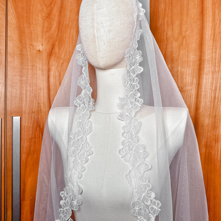 Close-up of the soft bridal tulle and embroidered butterfly lace trim of the mantilla style veil.