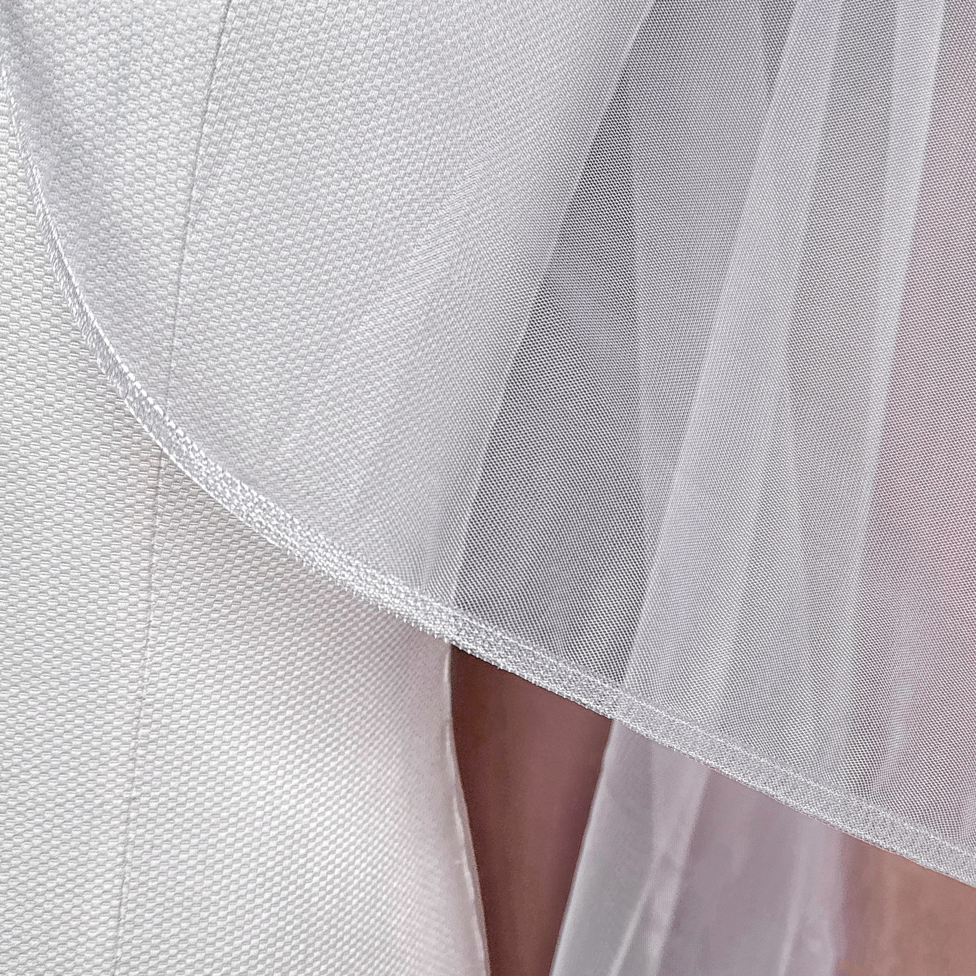 Close-up detail of the 1/4 inch horsehair trim on a soft tulle cascade fingertip length wedding veil.