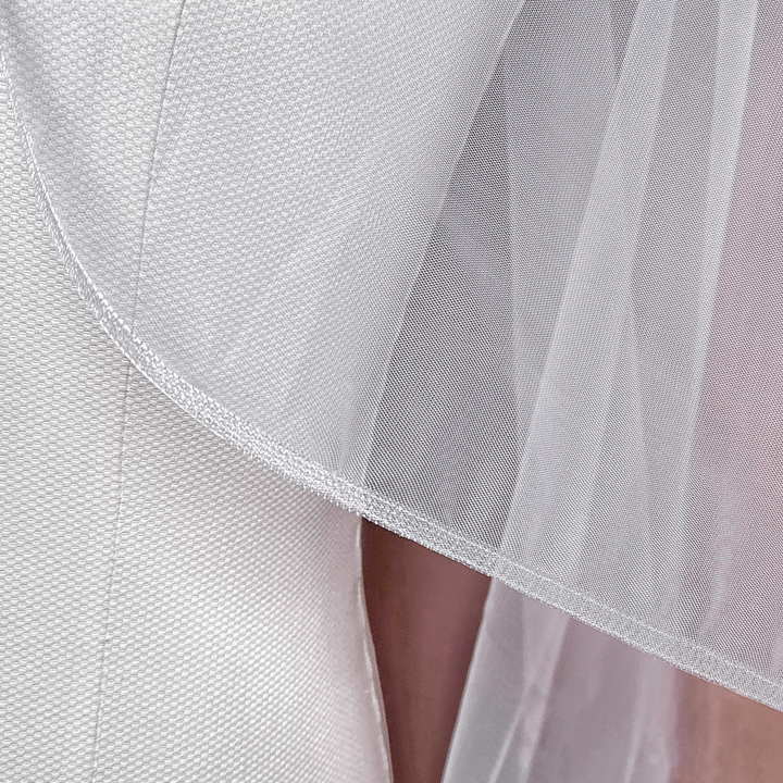 Close-up detail of the 1/4 inch horsehair trim on a soft tulle cascade fingertip length wedding veil.