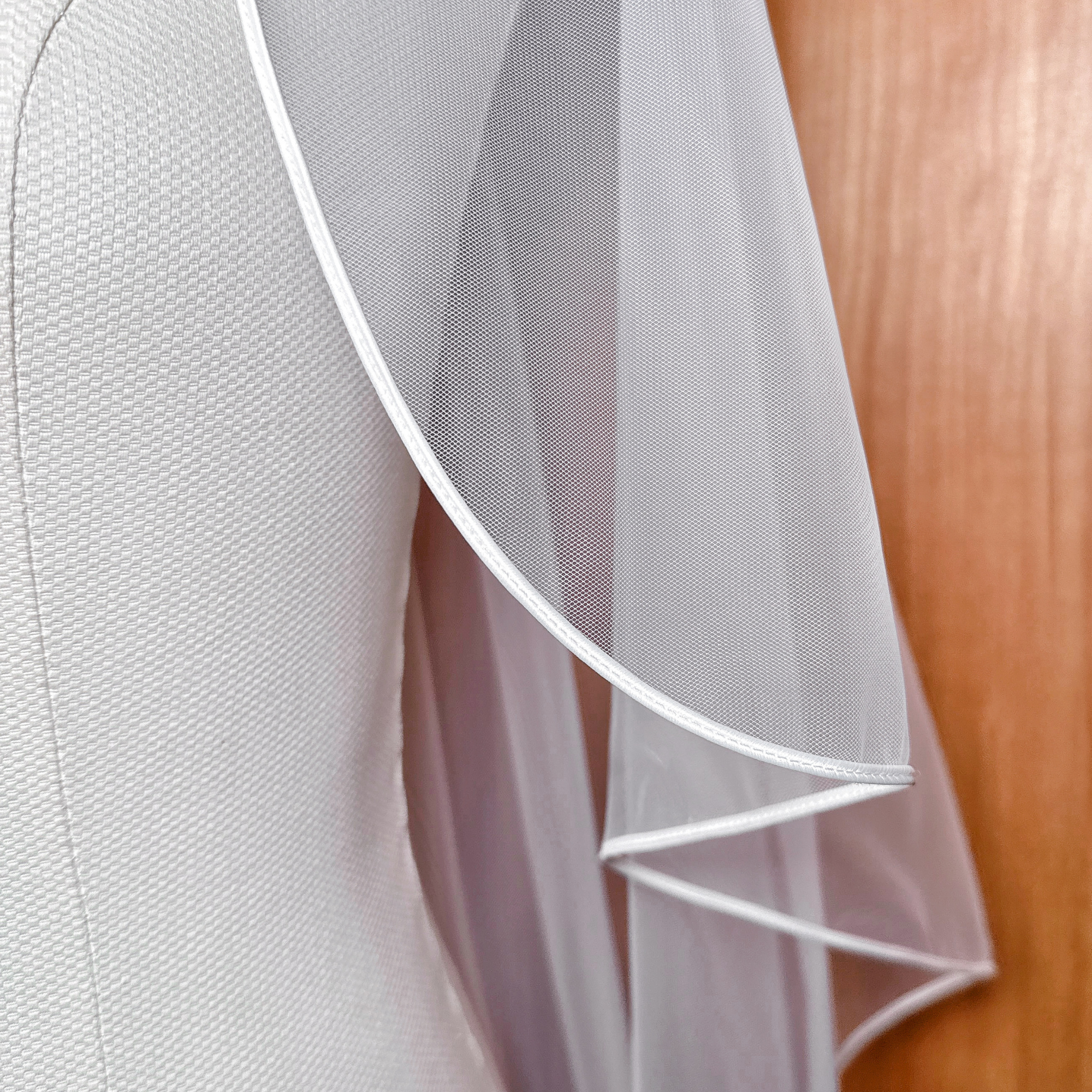 Close-up shot of the corded edge embroidery on the cascade fingertip wedding veil.