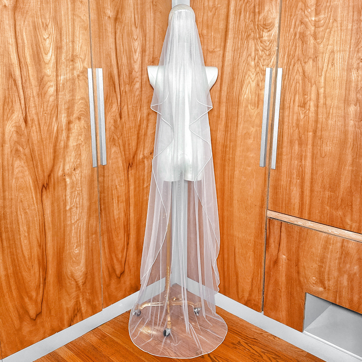 Top view of the secure hair comb attachment on a cascade floor wedding veil with corded edge.