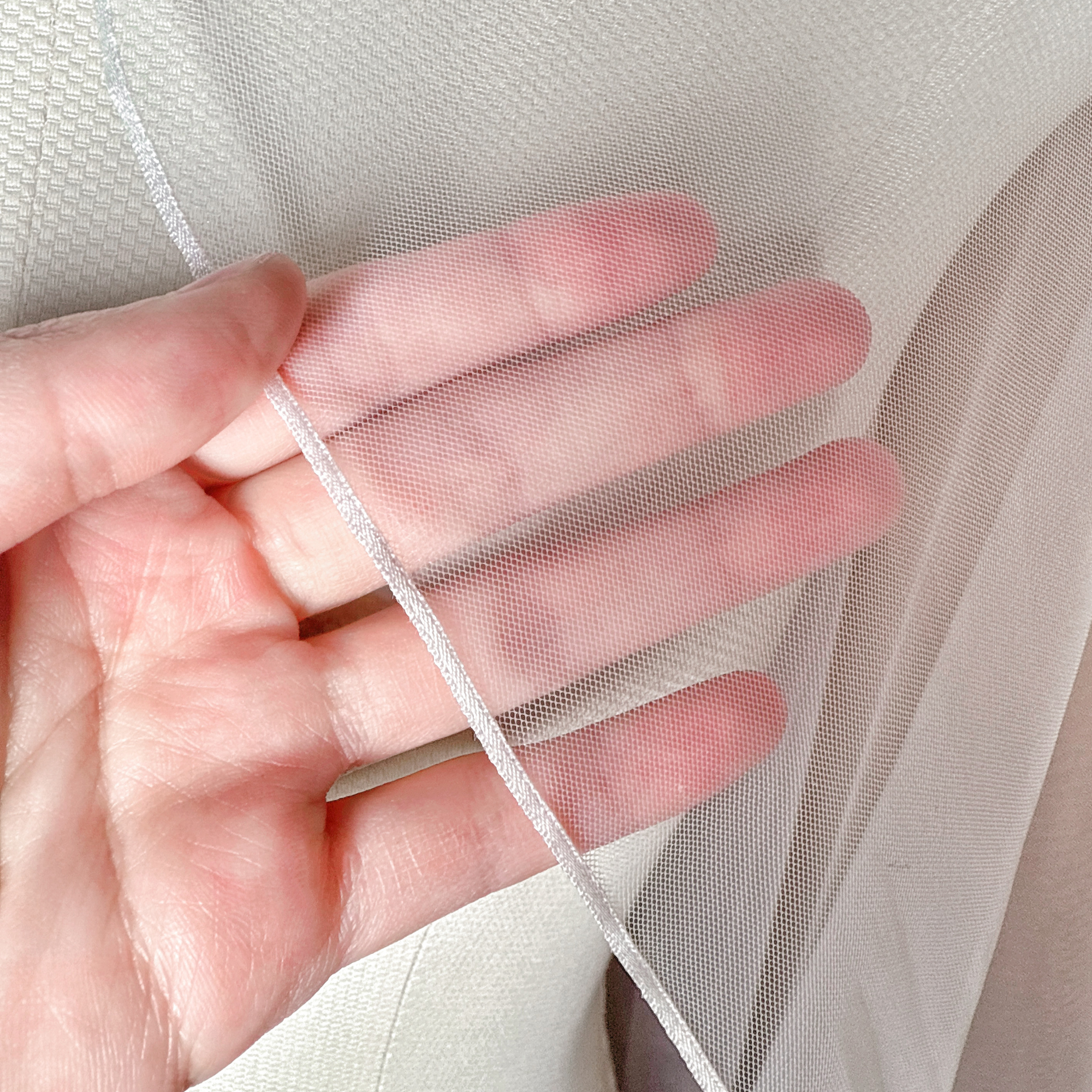 Close-up shot of the delicate micro ribbon trim on a cascade knee length wedding veil.