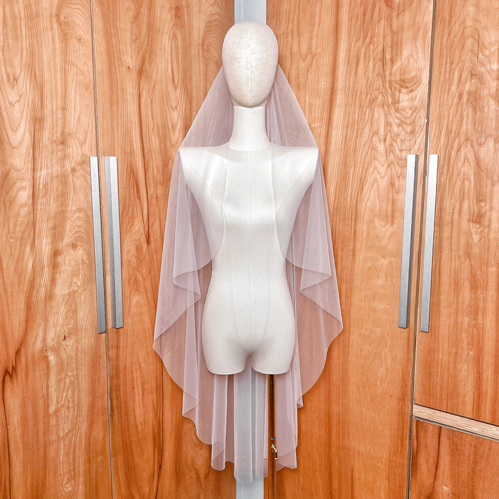 Front view of a sheer cascade knee-length wedding veil with a clean raw edge finish.