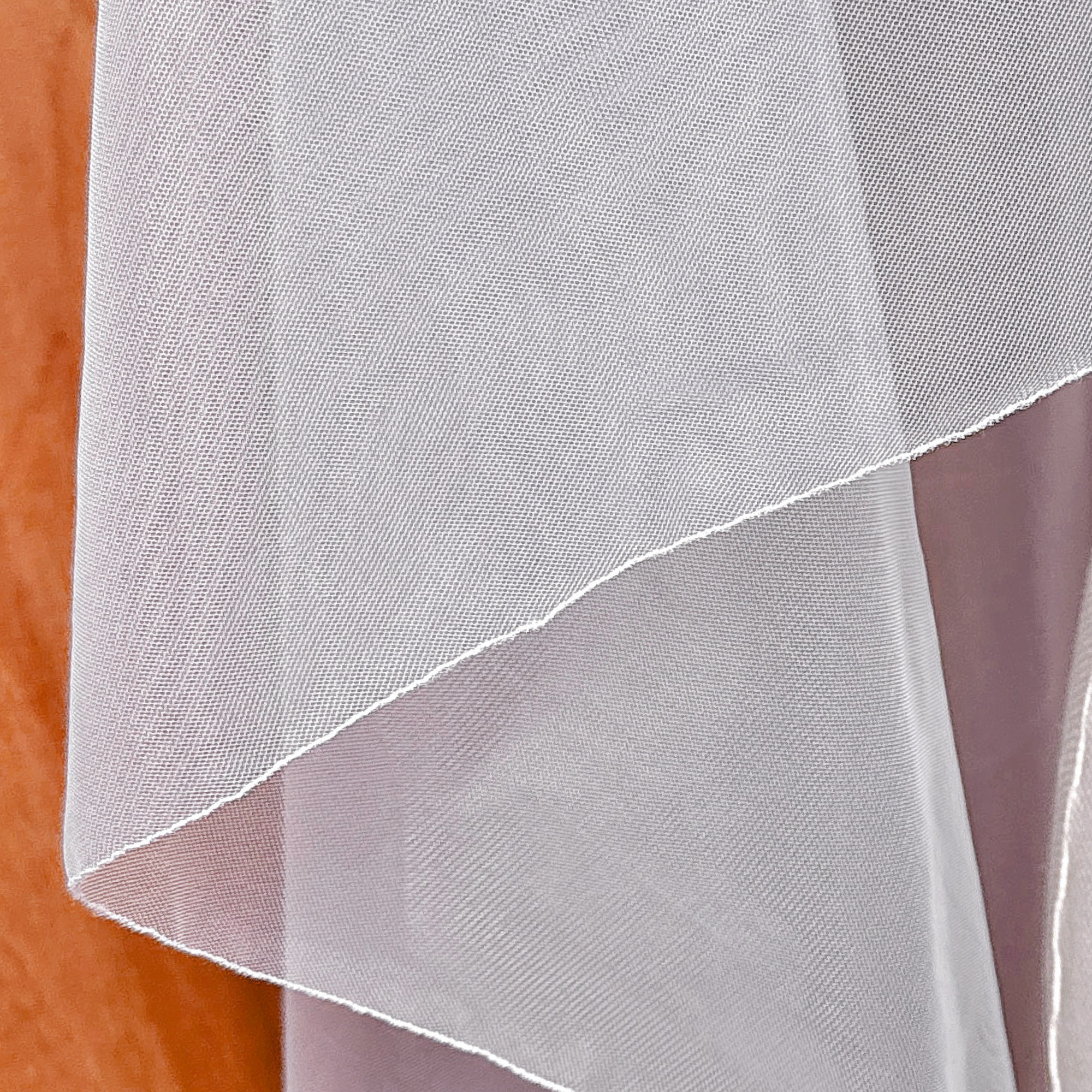 Close-up of the delicate pencil edge stitching on a cascade waltz-length wedding veil.