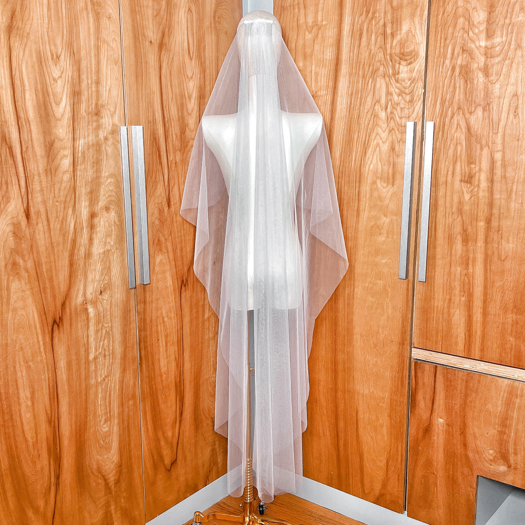 Rear view showing the graceful waterfall drape of the waltz length cascade wedding veil.
