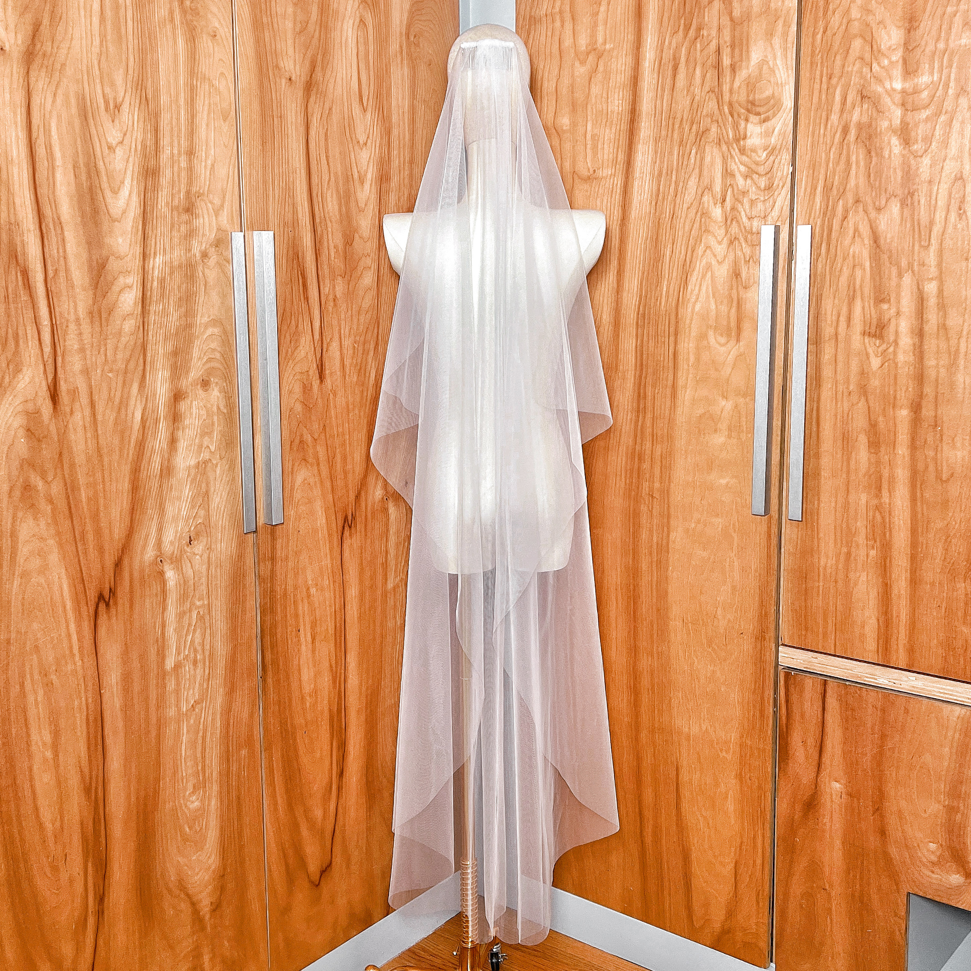 Secure metal comb attachment at the top of the waltz length cascade wedding veil.