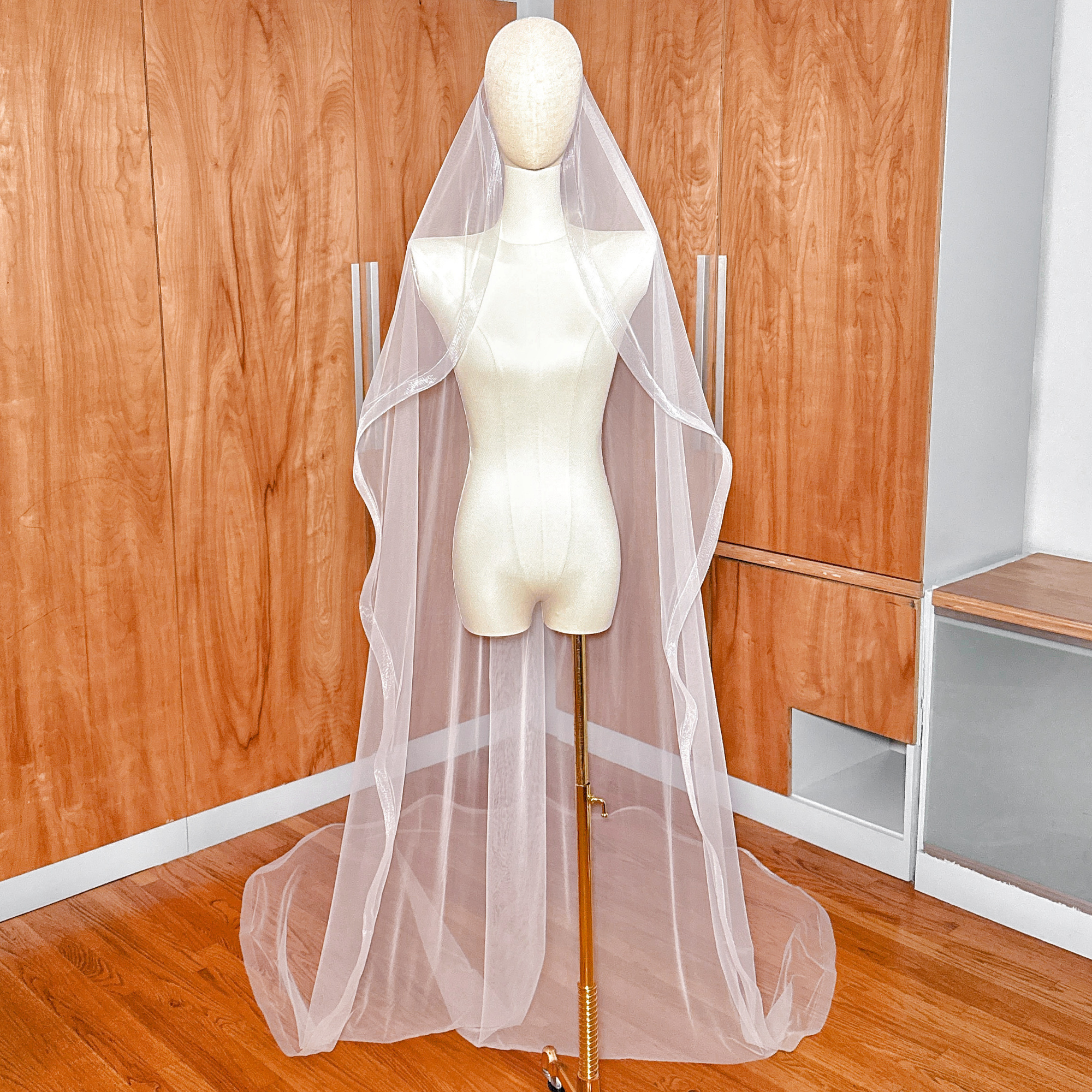 Cathedral length cascade wedding veil with 1.5 inch horsehair trim displayed on a bridal mannequin.