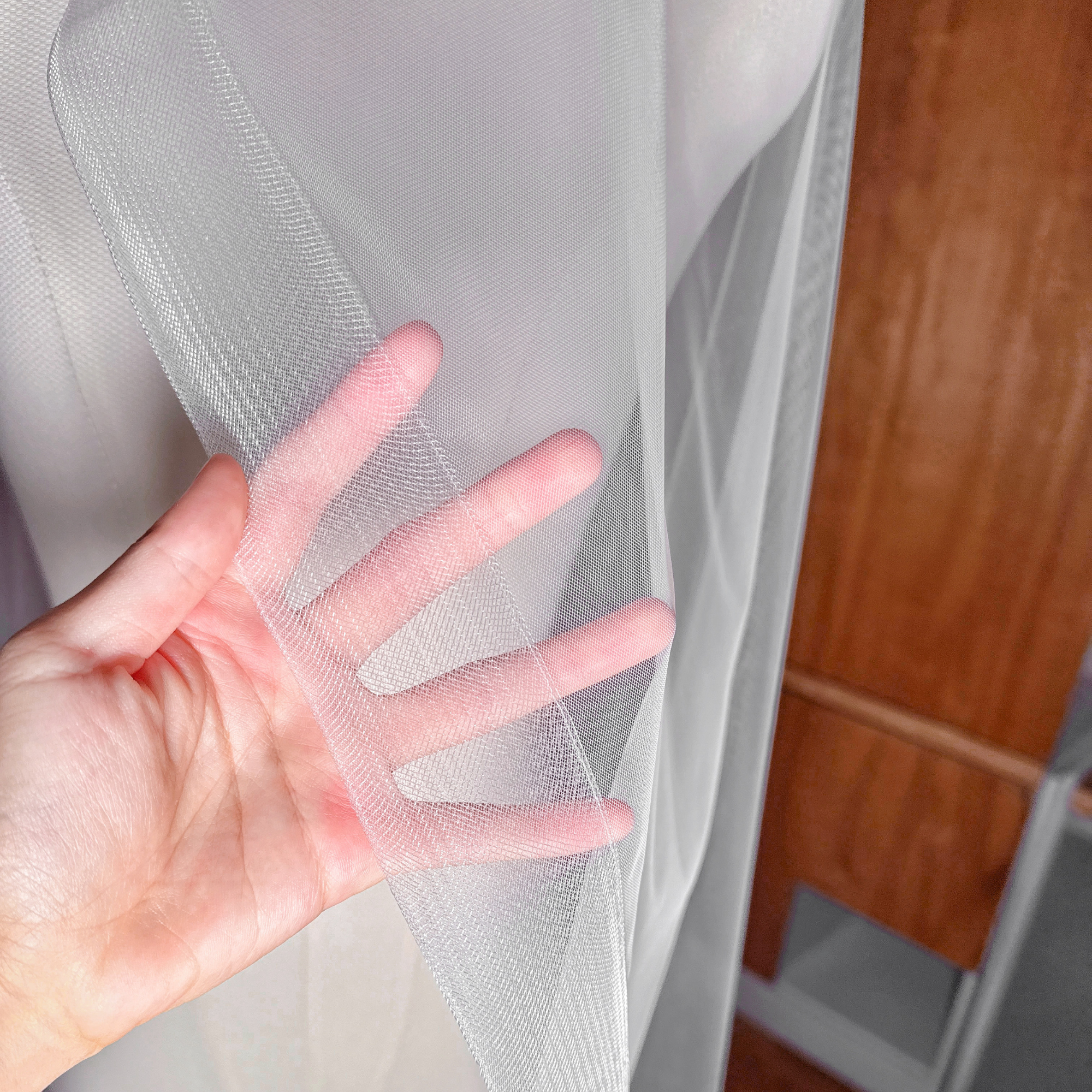 Close-up of the 2-inch horsehair trim on a cathedral-length cascade wedding veil showing the structured crinoline edge.