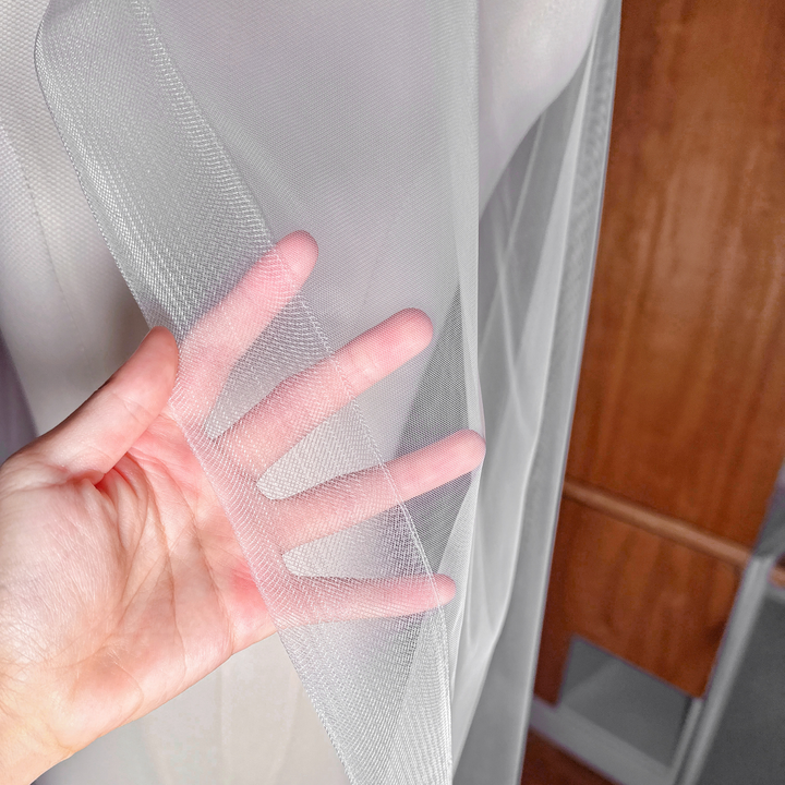 Close-up of the 2-inch horsehair trim on a cathedral-length cascade wedding veil showing the structured crinoline edge.