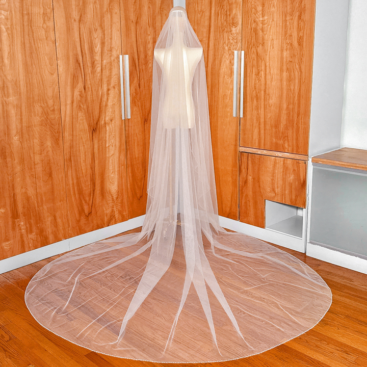 Back view displaying the full cathedral length and drape of the cascade wedding veil with beaded edge.