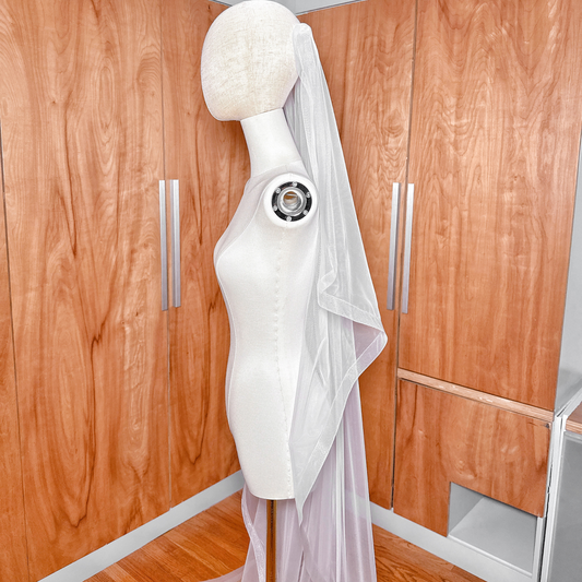 Mannequin wearing a cascading angel cut wedding veil in cathedral length with a crisp 1-inch horsehair border.