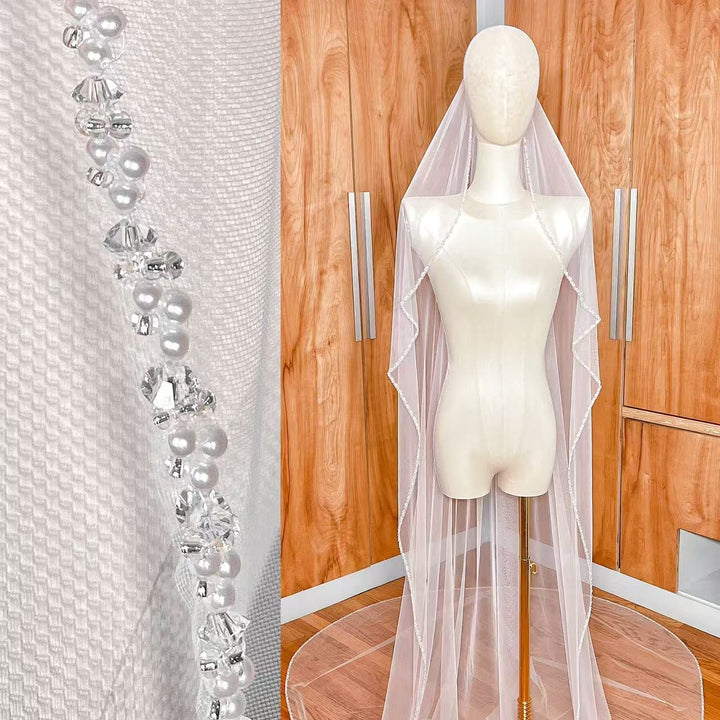 A cathedral length cascading beaded edge wedding veil draped elegantly to show its full floor-sweeping length.