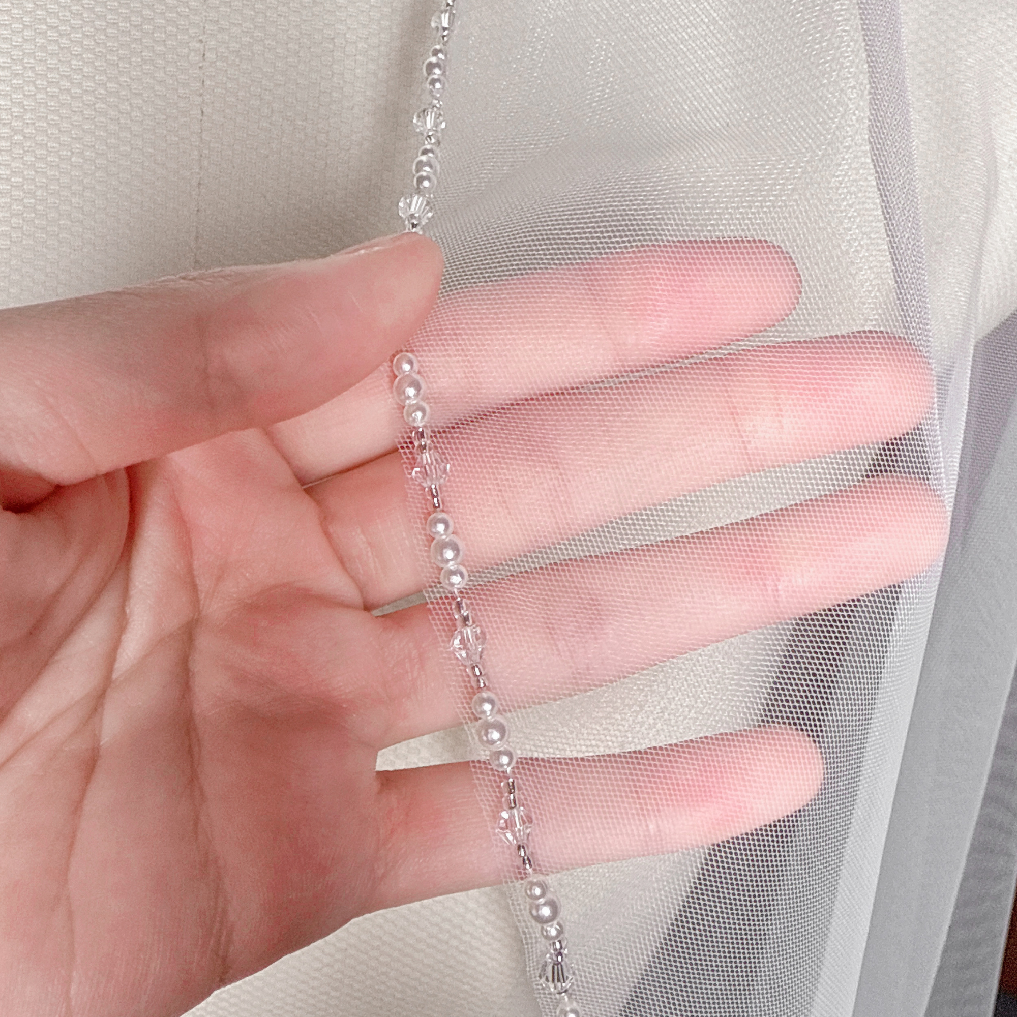 Detailed view of the intricate cascading beads along the edge of a cathedral wedding veil.