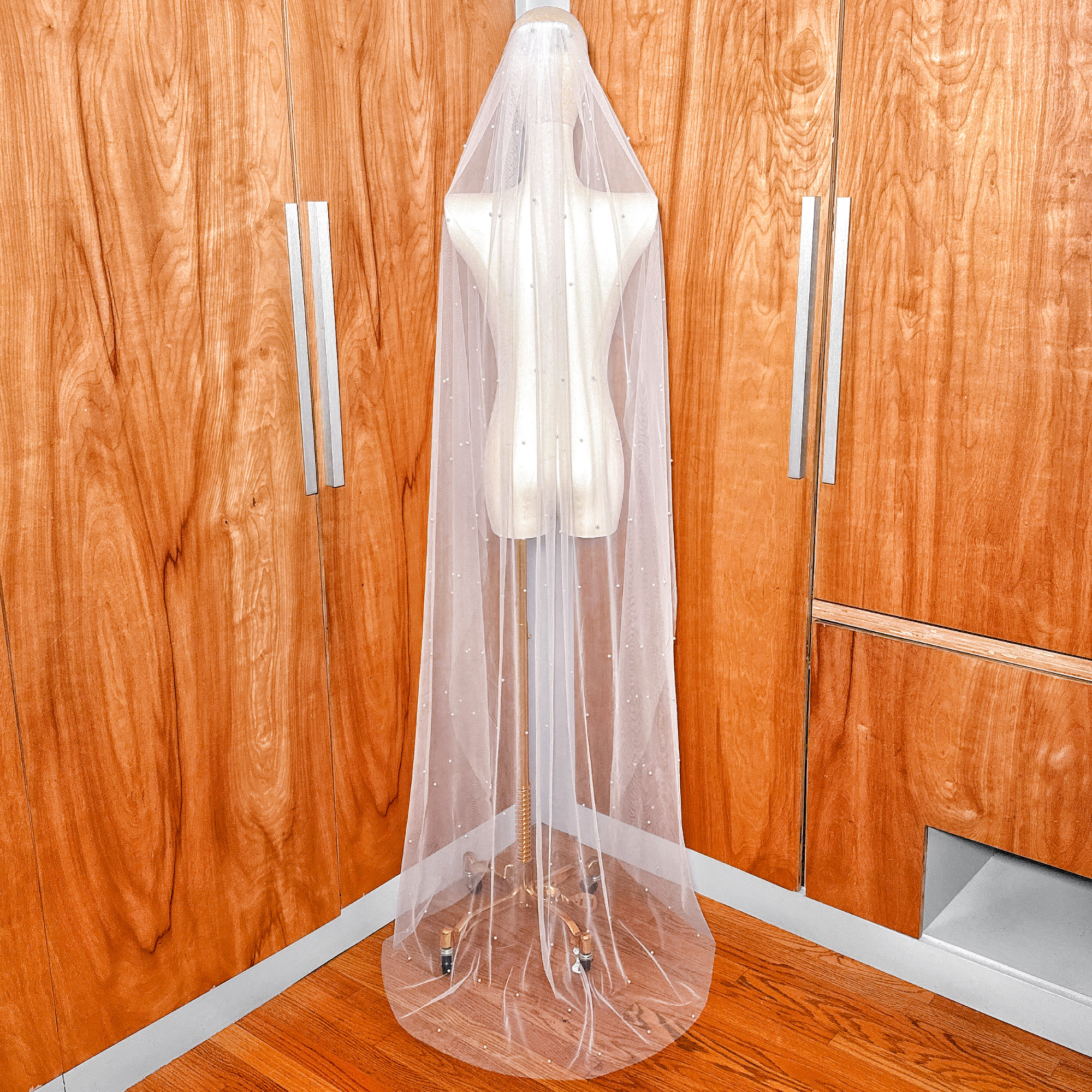 Back view of a cascading scattered pearl wedding veil highlighting the sheer tulle and pearl density.