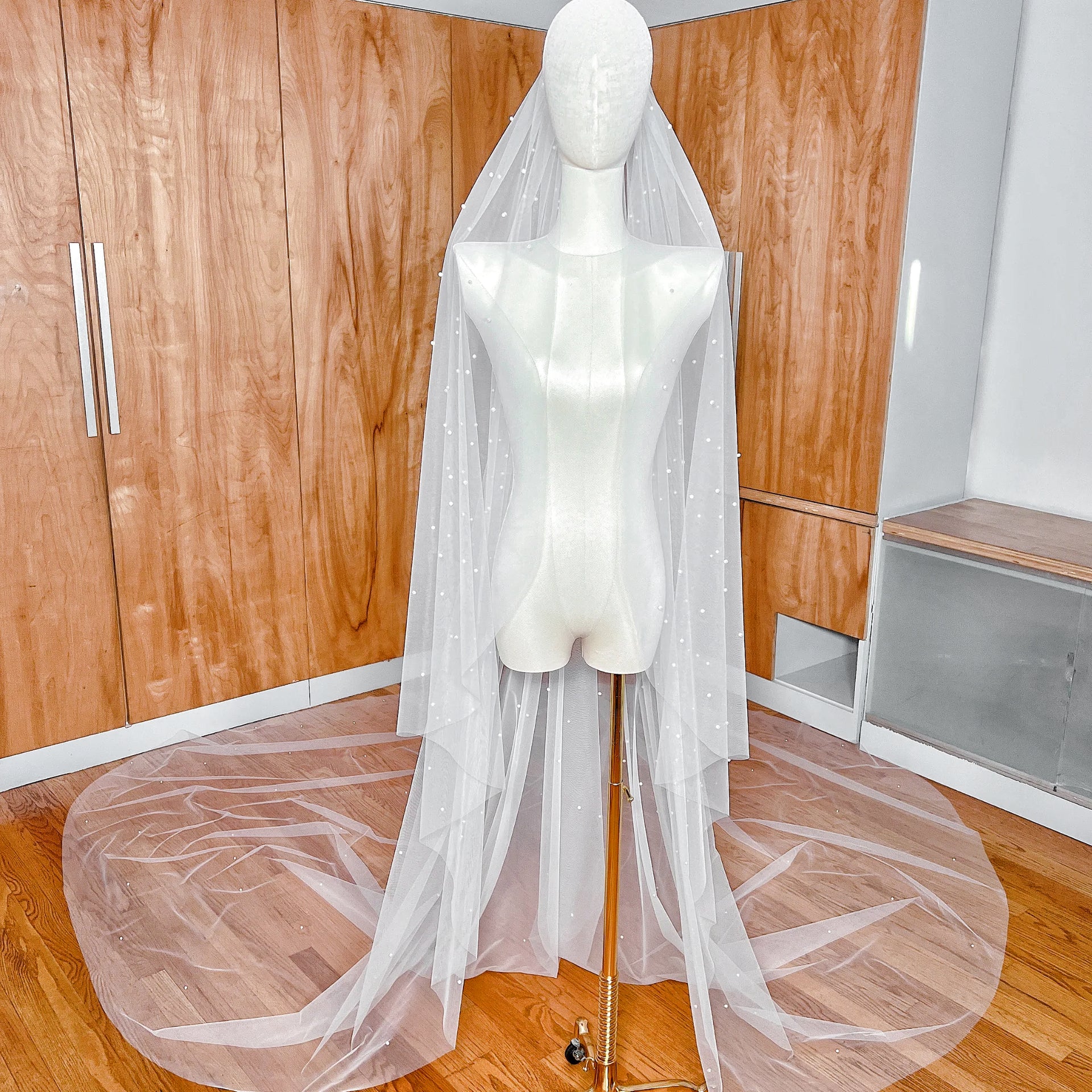Royal cathedral length cascading scattered pearl wedding veil draped elegantly to show full 144-inch span.