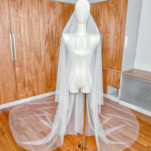 Royal cathedral length cascading scattered pearl wedding veil draped elegantly to show full 144-inch span.