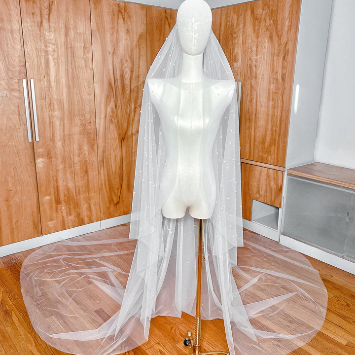 Royal cathedral length cascading scattered pearl wedding veil draped elegantly to show full 144-inch span.