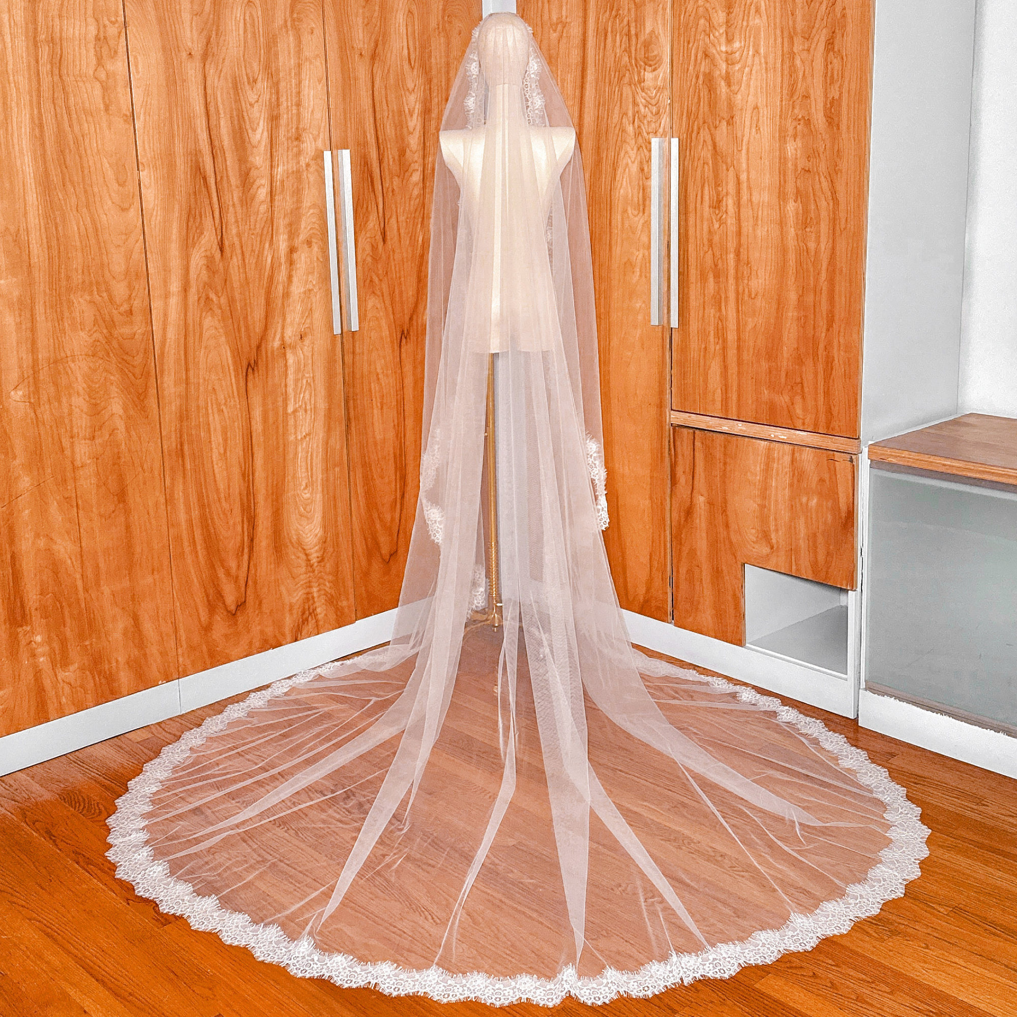 Rear view of a cathedral length Chantilly lace mantilla veil showing the full drape on a mannequin.