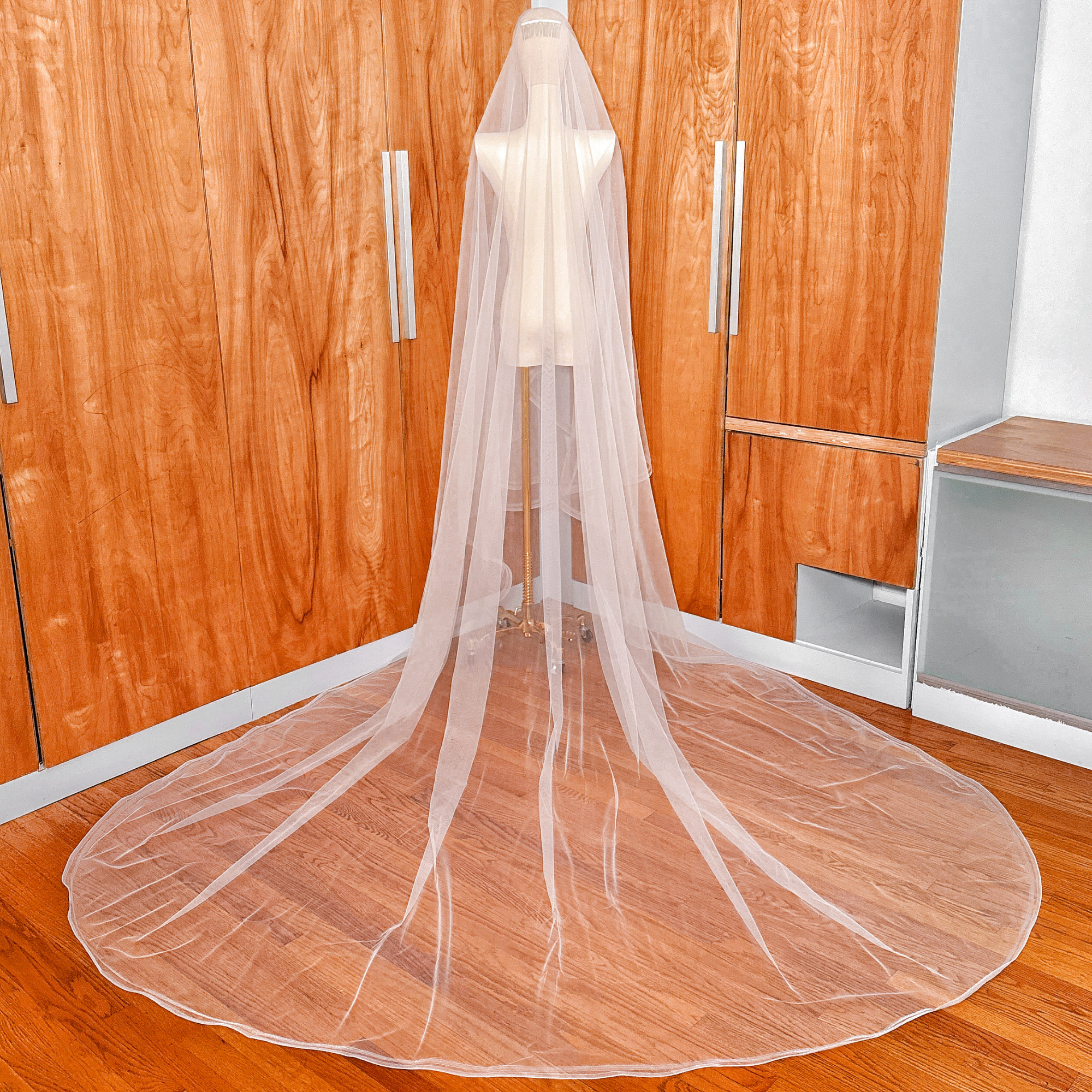 Long cathedral style double horsehair bridal veil draped over a bridal dress form.